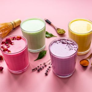 Green, yellow and pink latte. Hot colorful coffee or tea with milk