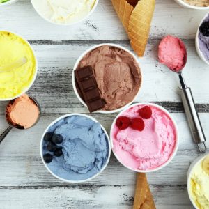 Various of ice cream flavors blueberry, strawberry, kiwi, lemon, vanilla setup on rustic background . Summer and Sweet menu concept.